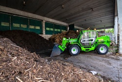 Merlo P72.10Plus telehandler with bucket attachment scooping mulch
