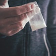 Drug dealer holding a bag of cocaine