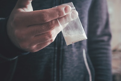 Drug dealer holding a bag of cocaine