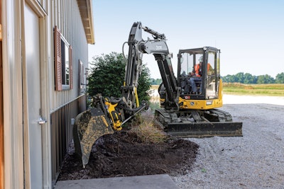 Deere 60G compact excavator digging beside building