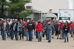 Members of UAW Local 180 walk out of the CNH Industrial plant