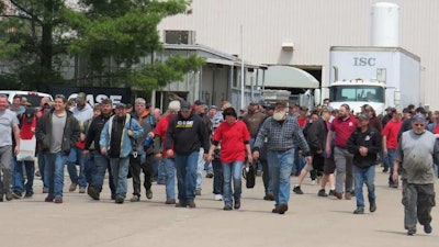 Members of UAW Local 180 walk out of the CNH Industrial plant