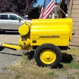 yellow restored 1943 Ingersoll-Rand-air-compressor parked by house
