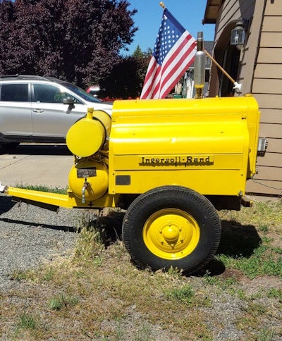 yellow restored 1943 Ingersoll-Rand-air-compressor parked by house