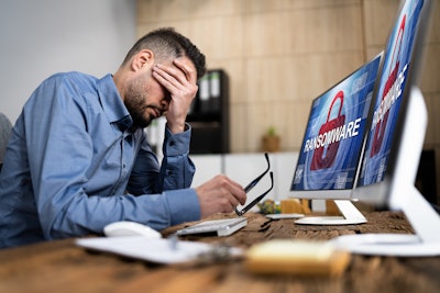 Man sitting in front of his computer after a ransomware attack