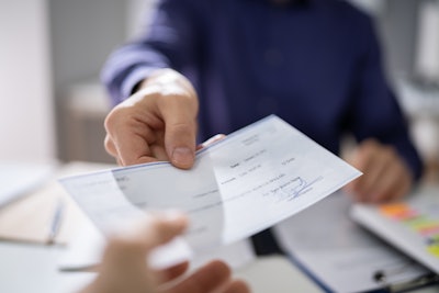 Payroll manager handing an employee a check