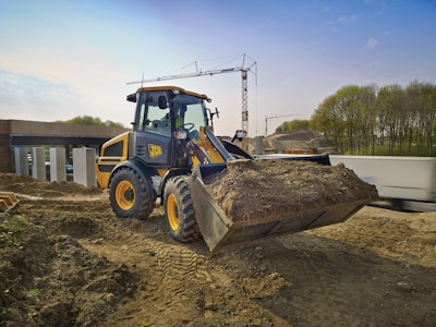 JCB 409 compact wheel loader carrying bucket full of dirt