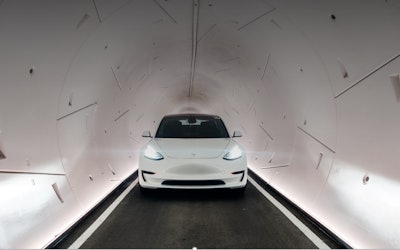 white Tesla travels through Boring Company Loop underground tunnel Las Vegas