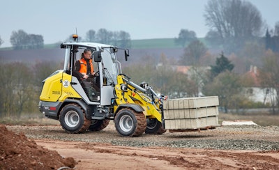 Wacker Neuson WL28 compact Wheel Loader carrying bricks with fork attachment
