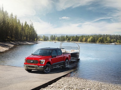 red 2023 Ford F-150 Heritage towing boat out of boat launch