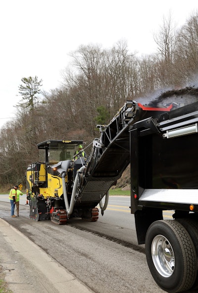 BOMAG BM 2200/65 Cold Planer vertical photo asphalt milling shooting from conveyor into back of dump truck