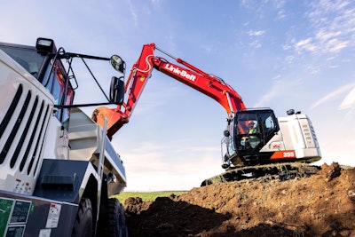 Link-Belt 355 X4S excavator on dirt pile arm extended after emptying bucket in truck bed