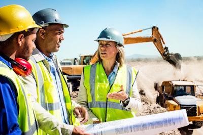 construction employees wearing safety vests and hats on a job site