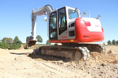 Takeuchi TB2150 excavator in dirt with bucket poised to dig