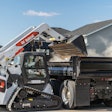 Bobcat T76 compact track loader emptying bucket into a dump truck