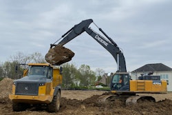 Werk Brau excavator 6 yard bucket poised with full bucket load on Deere excavator over Deere dump truck