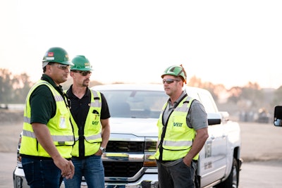 Three Veit construction workers standing in front of a company truck