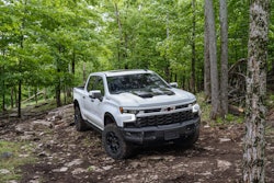 2023 Chevy Silverado ZR2 Bison white parked in woods on trail surrounded by trees