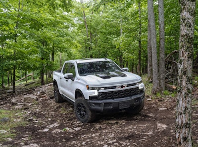 2023 Chevy Silverado ZR2 Bison white parked in woods on trail surrounded by trees