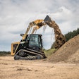ASV RT-75HD compact track loader dumping dirt from bucket onto dirt pile