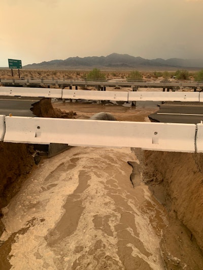 Interstate 10 washed out California Arizona border muddy water roils beneath destroyed road yet concrete barriers still in tact
