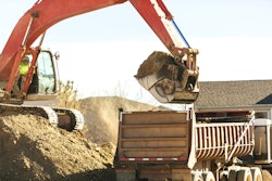 Excavator loading a dump truck with dirt