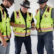 Three construction workers review data on tablet