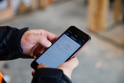 Hands holding cell phone using Raken app