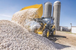 John Deere G-tier wheel loader dumping at a rock pile.