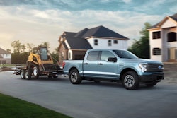 A photo released by Ford shows the 2022 F-150 Lightning towing a track loader.