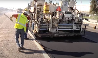 Paver and crew lay rubberized asphalt made with recycled tires