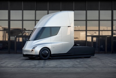 Tesla tractor electric semi silver in front of glass building