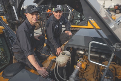 Two diesel technicians working on a piece of construction equipment
