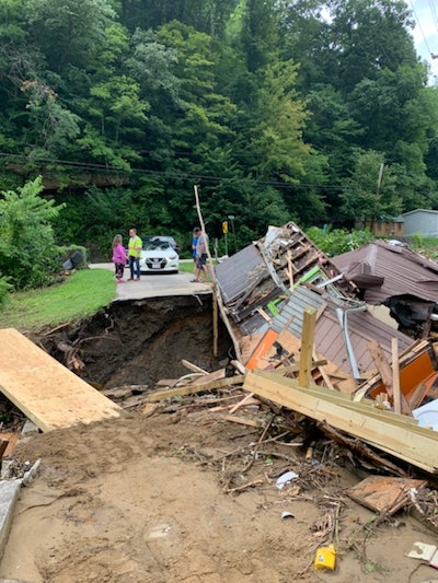 kentucky floods collapsed road with housing debris in middle of sinkhole in road
