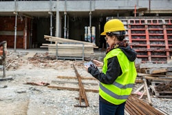 construction worker wearing bright yellow safety vest and hat on a job site