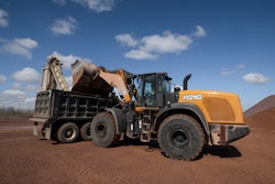 CASE 1121 G wheeled loader dumping load into a dump truck