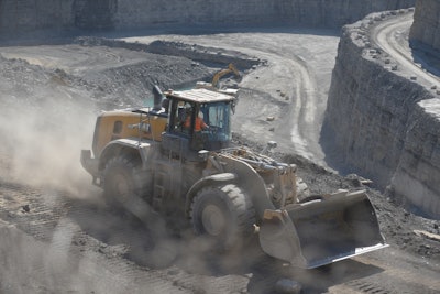 Cat 980 wheel loader traveling in dusty quarry