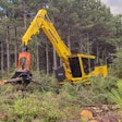Komatsu PC230F-11 forestry- processor grabbing logs in cleared forest section
