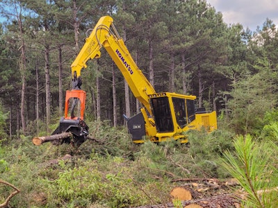 Komatsu PC230F-11 forestry- processor grabbing logs in cleared forest section
