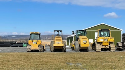 Caterpillar construction equipment parked outside a shop