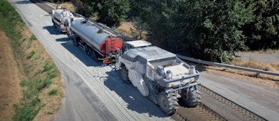 graphic Wirtgen WR cold recycler following trucks on road paving project
