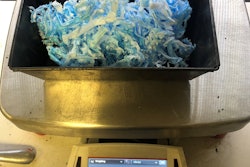 Covid masks shredded weighed for use in asphalt mix sitting in metal container on scale showing 29 grams