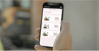 Person holding a cell phone with Volvo's Electric Machine Management app