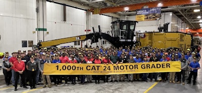 Cat production team with banner honoring 1000th Cat 24 motor grader