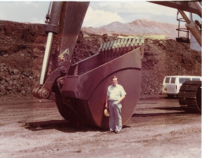 Bill Wright, ASCO Founder, standing next to a bucket
