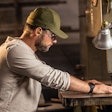 Man at bandsaw with earbuds