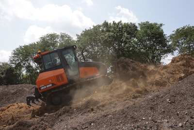 orange Doosan DD1100 dozer pushing dirt up hill