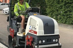 Dynapac CC900 e Z.ERA electric tandem-drum vibratory compactor with operator in high-vis green hardhat and vest compacting asphalt