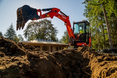 Kubota KX030-4 compact excavator behind dirt trench bucket raised to side