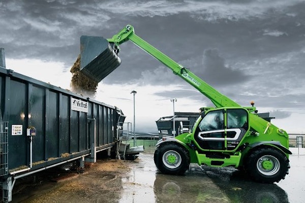 Merlo TF65.9 telehandler green dumping material in truck trailer